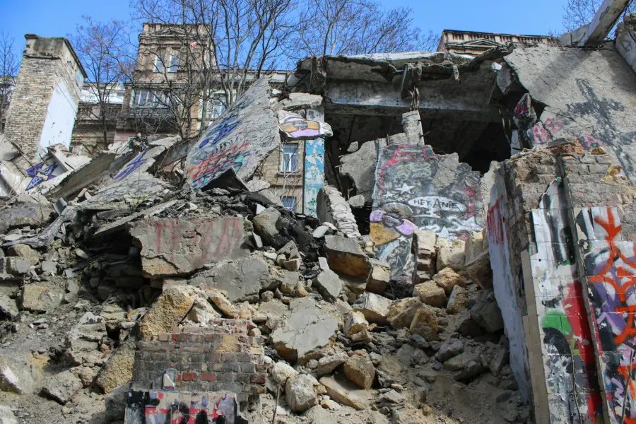 A pile of rubble next to a building with graffiti on it